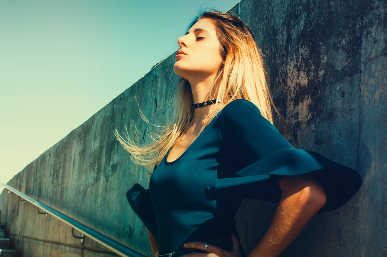 Woman Wearing Blue Scoop-neck Top Standing Near Gray Concrete Wall